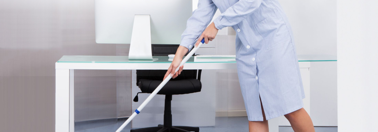 portrait of happy female janitor cleaning floor at office