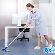 portrait of happy female janitor cleaning floor at office