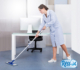 portrait of happy female janitor cleaning floor at office
