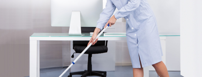 portrait of happy female janitor cleaning floor at office